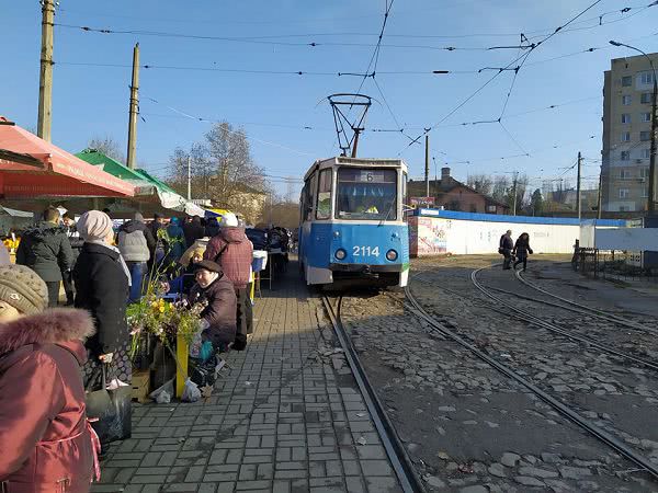 Вагоны трамваев почти упираются в спины покупателей на рынке Колос в Николаеве