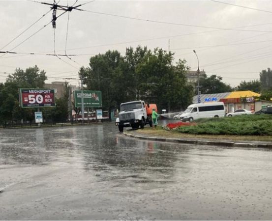 В центре Николаева в сильный дождь работники ЖКХ поливали клумбы!